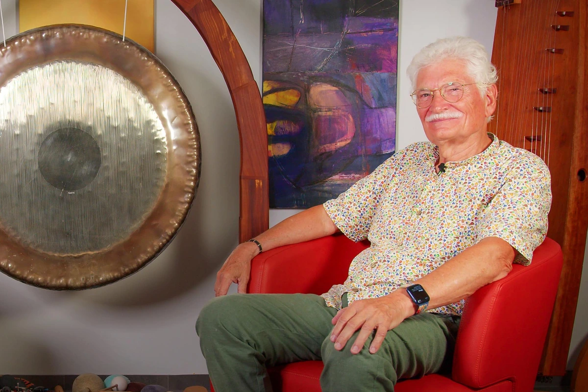 Dr. med. Peter Hess mit Gong in seiner Praxis